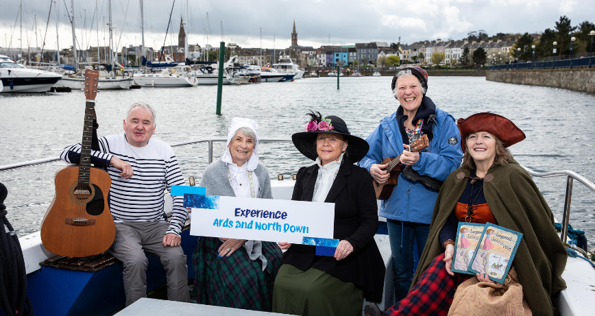 A group consisting of Brian Meharg, Skipper of the Ocean Crest in Bangor, characters in dress representing the historic stories incorporated into the tours, and Tour Guide Alison Armstrong.